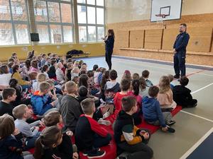 Policjanci i uczniowie podczas spotkania w sali gimnastycznej.