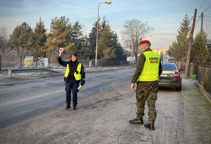 Policjantka wspólnie z funkcjonariuszem Żandarmerii Wojskowej podczas działań na drodze