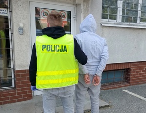 policjant prowadzi zatrzymanego