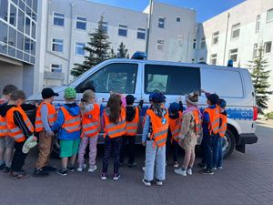 Dzieci i policjanci podczas wizyty w komisariacie.