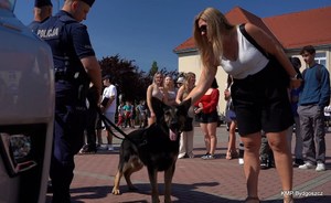 Policyjny pies służbowy głaskany przez jednego z uczestników drzwi otwartych