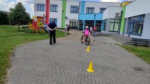 Dzieci pod okiem policjanta zdają egzamin praktyczny na kartę rowerową.