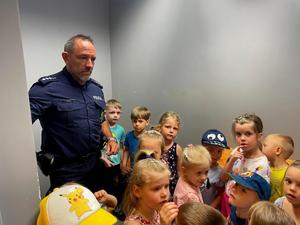 Dzieci i policjanci podczas zwiedzania komisariatu.