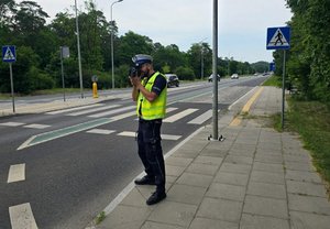 Policjant ruchu drogowego podczas mierzenia prędkości kierujących