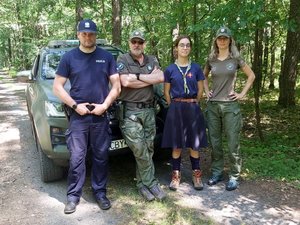 Zdjęcie policjanta i strażników leśnych z harcerzami