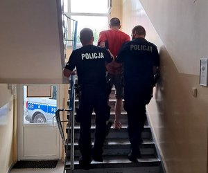 Policjanci prowadzą zatrzymanego.