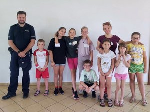 Zdjęcie grupowe policjanta z dziećmi uczestniczącymi w spotkaniu