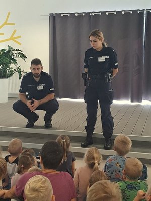 Policjanci i dzieci podczas spotkania w świetlicy przedszkola.