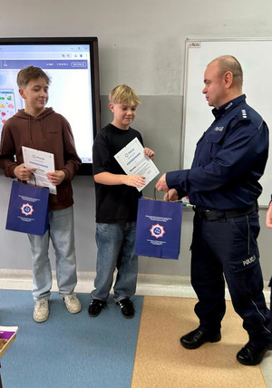 Michał i Antoni oraz nauczyciele i policjanci podczas podziękowań.