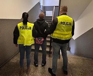 Policjanci prowadzą zatrzymanego.