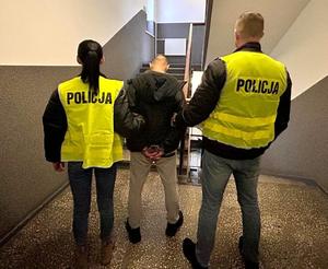 Policjanci prowadzą zatrzymanego.