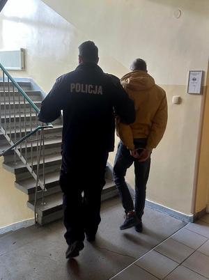 policjant prowadzi zatrzymanego