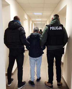 policjanci prowadzą zatrzymanego