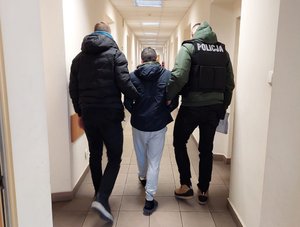 policjanci prowadzą zatrzymanego