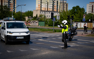 Policjanci wydziału ruchu drogowego podczas działań dotyczących zabezpieczenia przejazdu.