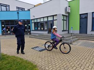 Dzielnicowy i uczniowie podczas egzaminu praktycznego na kartę rowerową.