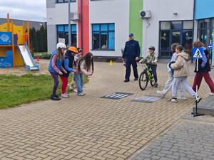 Dzielnicowy i uczniowie podczas egzaminu praktycznego na kartę rowerową.