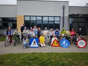 Dzielnicowy i uczniowie podczas egzaminu praktycznego na kartę rowerową.