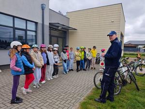 Dzielnicowy i uczniowie podczas egzaminu praktycznego na kartę rowerową.