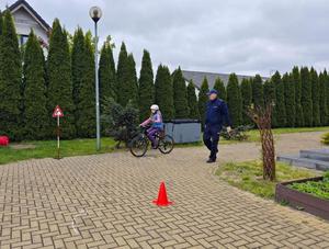 Dzielnicowy i uczniowie podczas egzaminu praktycznego na kartę rowerową.