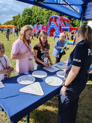 Policjantka wraz z Polfinkiem podczas festynu z okazji Dnia Dziecka.