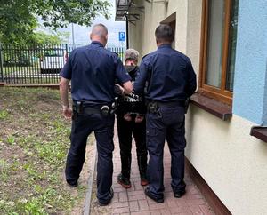 Policjanci prowadzą zatrzymanego.