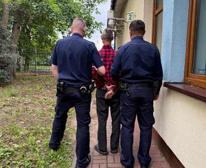 Policjanci prowadzą zatrzymanego.