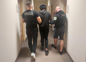 Policjanci prowadzą zatrzymanego.