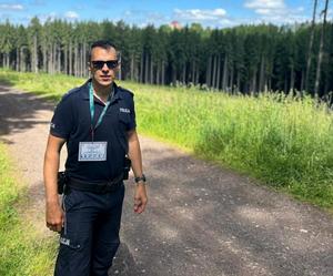 Policjanci podczas marszu w terenach zielonych.