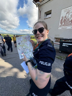 Policjanci podczas marszu w terenach zielonych.