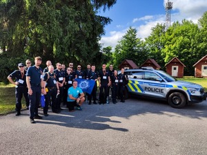 zdjęcie grupowe policjantów z innymi uczestnikami przy radiowozie policyjnym