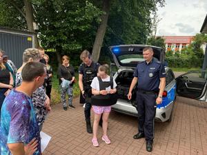 Podopieczni Warsztatu Terapii Zajęciowej, ich opiekunowie oraz policjanci podczas spotkania.