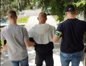 policjanci prowadzą zatrzymanego