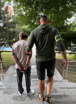 policjant prowadzi zatrzymanego