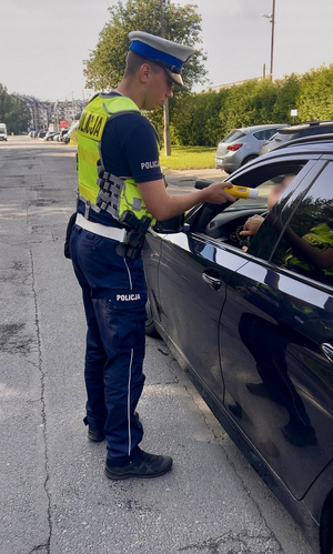 policjant ruchu drogowego bada trzeźwość kierujących
