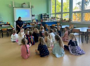 Policjantka podczas spotkania z uczniami w sali szkolnej.