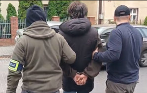 Policjanci prowadzą zatrzymanego.