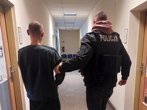 policjant prowadzi zatrzymanego