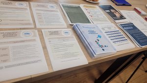 Broszury informacyjne porozkładane na stole.