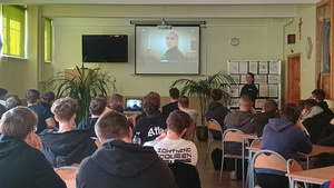 Policjantka i policyjna profilaktyk oraz uczniowie podczas zajęć.