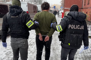 policjanci prowadzą zatrzymanego