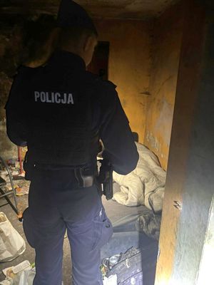 Policjant podczas sprawdzania miejsca przebywania osoby w kryzysie bezdomności.