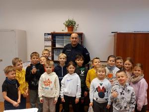 Policjanci i dzieci podczas spotkania w komisariacie.