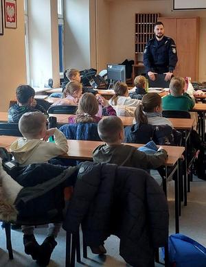 Policjanci i dzieci podczas spotkania w komisariacie.