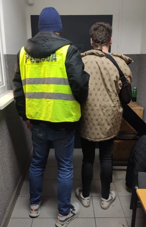 Policjant stoi z zatrzymanym.