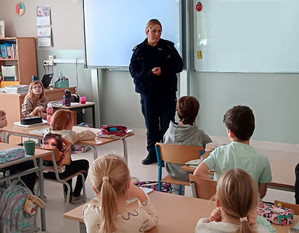 Policjantka i dzieci podczas zajęć w klasie szkolnej.