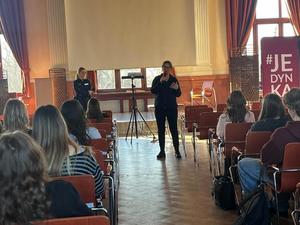 Policyjni profilaktycy i uczniowie podczas prelekcji w auli szkoły.