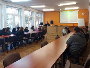 Policjant i uczniowie podczas zajęć w sali szkolnej.