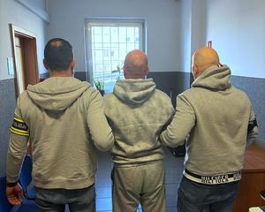 Policjanci prowadzą zatrzymanego.