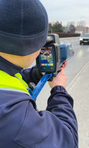 policjanci w trakcie pomiaru prędkości ręcznym miernikiem